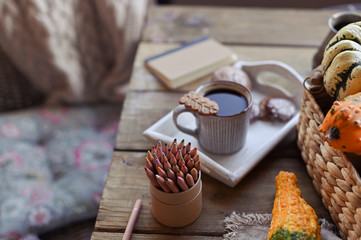 Autumn, pumpkins, hot steaming cup of coffee on a wooden table background. Seasonal, morning coffee, sunday relaxing and still life concept. Plans for the day.