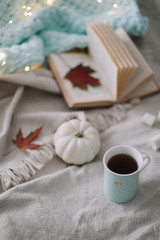 Autumn still life. A cup, dried leaves, book and pumpkin. Hygge lifestyle, cozy autumn mood. Flat lay, thanksgiving background