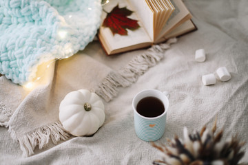 Autumn still life. A cup, dried leaves, book and pumpkin. Hygge lifestyle, cozy autumn mood. Flat lay, thanksgiving background