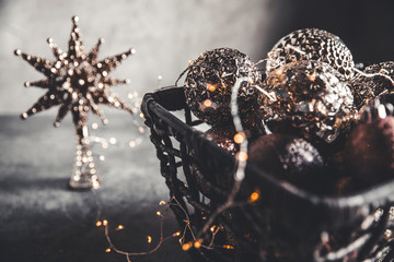 Wicker basket with Christmas toys and holiday decorations lights, copy space, new year decoration