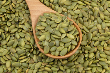 Pumpkin seeds and wooden spoon, top view