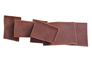 Heap of parts of broken bar dark bitter or milky chocolate isolated on white background without...