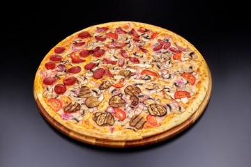 Pizza "Four Seasons" on wooden board on black concrete