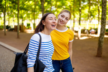 Obraz premium happy mother and daughter walking ion park together
