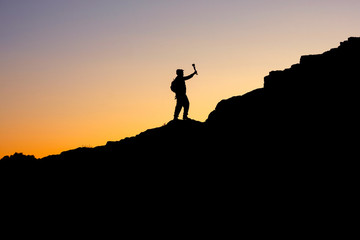 the photo on the sunset sky and mountain is visible in silhouette