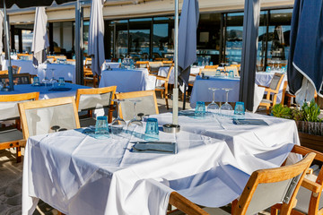 Outdoor restaurant tables on a clear sunny day. Cafe on the beach.
