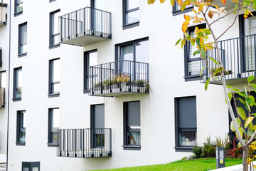 Exterior of a modern  apartment buildings with balcony and white walls.