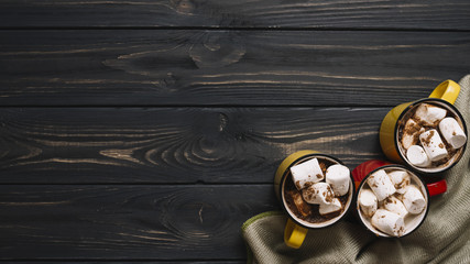 Mugs with marshmallows near cloth