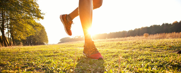 One young man is jogging cross-country through the pathway in the meadow