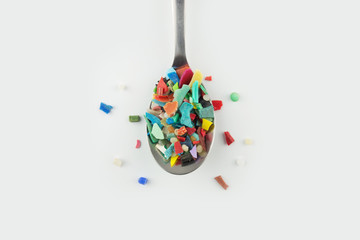 Spoon full of microplastics. Plastic pollution concept.
