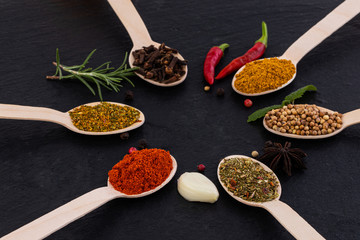 Colourful various herbs and spices on dark background