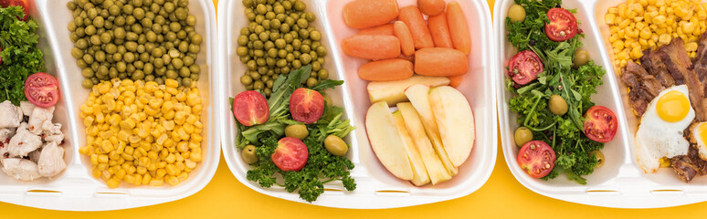 panoramic shot of eco packages with vegetables, apples, meat, fried eggs and salads isolated on yellow