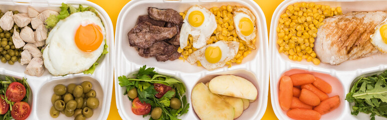 panoramic shot of eco packages with vegetables, apples, meat, fried eggs and salads isolated on yellow