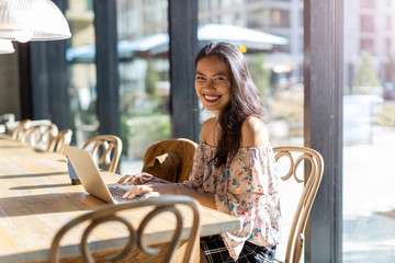Beautiful Filipino woman using laptop at cafe