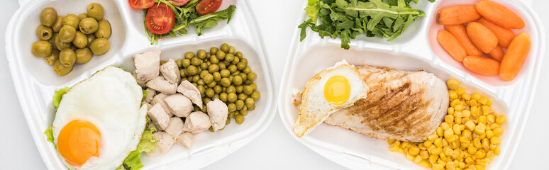 panoramic shot of eco packages with vegetables, meat, fried eggs and salad on white background