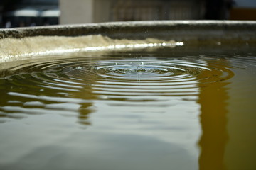 Fototapeta na wymiar drops of water falling in the fountain