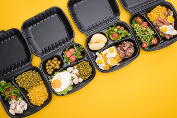 top view of eco packages with apples, vegetables, meat, fried eggs and salads isolated on yellow