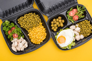 top view of eco packages with vegetables, meat, fried egg and salads isolated on yellow