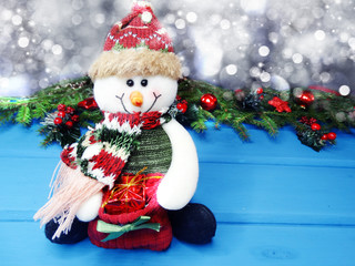 christmas snowman on fir tree branch with cones and snow on background