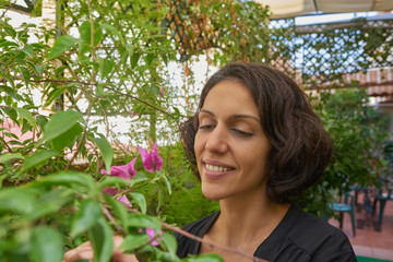  Brunette woman of Latin origin on a terrace doing gardening work.