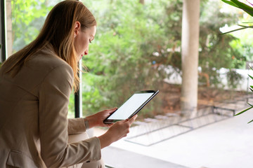 Young woman typing on digital tablet