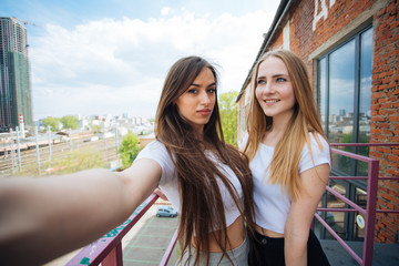 two very cute young girls posing as top models on a street in Europe on vacation,sisters actively posing on a sunny summer day ,very happy and joyful people