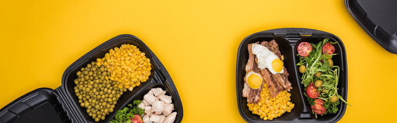 panoramic shot of eco packages with vegetables, meat, fried eggs and salad isolated on yellow