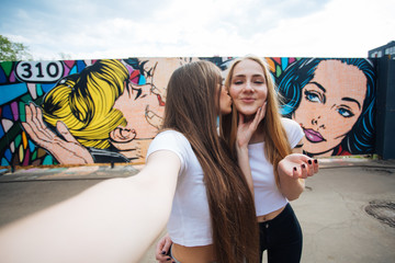 two very cute young girls posing as top models on a street in Europe on vacation,sisters actively posing on a sunny summer day,very happy and joyful people