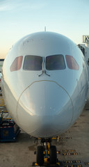 Airplane near the terminal in an airport at the sunset