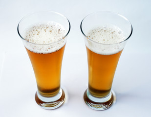 Two glasses of beer on a white background