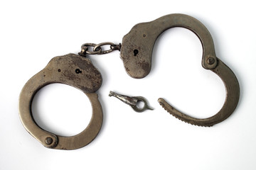 police handcuffs on a white background with a wrench