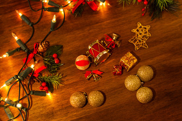 Adornos de Navidad con luces y bolas sobre mesa de madera rústica vista desde arriba