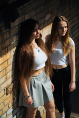 two very cute young girls posing as top models on a street in Europe on vacation,sisters actively posing on a sunny summer day,very happy and joyful people