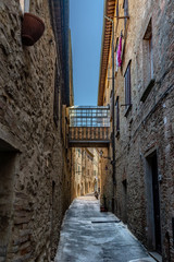 Fototapeta na wymiar Bridge Between Stone Buildings in Tuscany, Italy