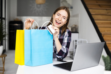 Young smiling woman showing shopping bags