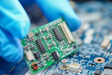 E-waste, technician repairing inside of hard disk by soldering iron. Integrated Circuit. the...