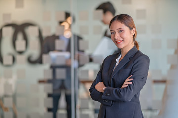 Portrait of young beautiful business woman in the office. Crossed arms	