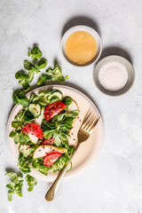 Sałatka z pomidorem, gruszką i roszponką na białym tle