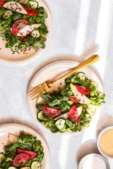 Sałatka z pomidorem, gruszką i roszponką na białym tle