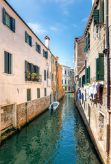 Narrow water canals in Venice, with small boats docked near the houses, Venice, Italy