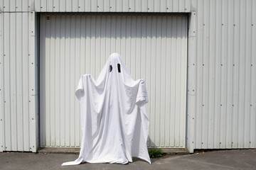 A white ghost in front of a garage door