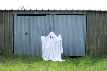 white ghost in front of a garage door