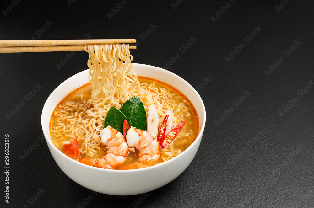 Wall mural Instant noodles, Tom Yum Kung flavor Spicy, spicy flavor with Thailand spices placed on the table, black background - Top view