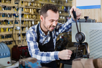 Male worker making key in specialized workshop
