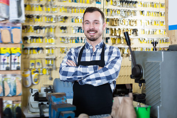 Happy worker showing his tools for making keys