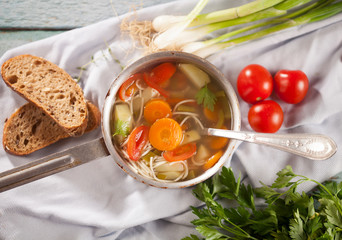 Delicious homemade vegetable soup close-up on a blue wooden table.