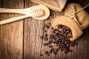 Fototapeta na wymiar Coffee beans in sack on wood table