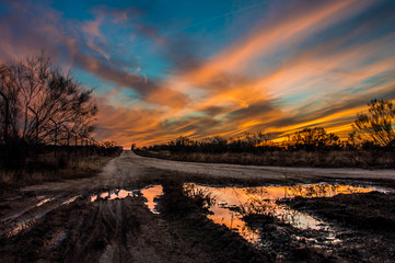 Una huella de dinosaurio refleja la puesta de sol en un camino del entorno Meaques-Retamares en...