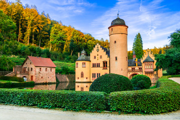 Moated castle Mespelbrunn with reflection in the water and green park, Spessart forest, Bavaria,...