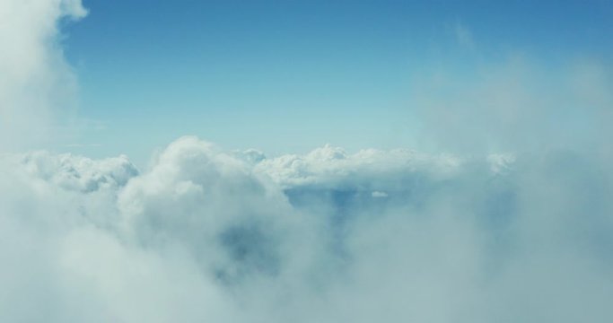 Aerial drone view flying forward through a sunny cloudscape mid day with blue skies, travel airlines freedom concept, cloudscape background